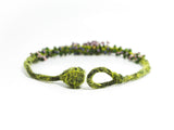 detail view of the open ball and hoop clasp on a green hand knotted and felted necklace with flameworked mini beads and mini lilac headpins. photo on white background.