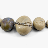 flameworked glass bead detail of three focal blown glass beads with blue aventurine stripe detail. on white background.