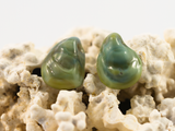 Detail of flameworked glass earring studs in a sea green colour.