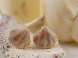 Detail front view of opalescent pink shell shaped flameworked glass earring studs.