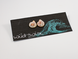 Shell shaped flameworked glass earring stud displayed on an earring card.