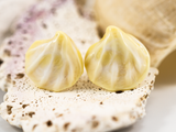 Detail view of front of flameworked glass earring studs in an ivory sands colour.