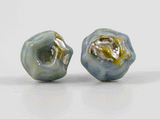 360 degree detail view of barnacle earrings with stainless steel ear stud. In a blue-green glass reminiscent of a mermaid tail with silver foil detail.