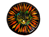 close up image of a round glass coaster showing the top design of the image of an sunflower on a black background. image is on a white background.