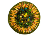 close up image of a round glass coaster showing the top design of the image of a sunflower on a dark green background. image is on a white background.