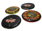 four glass coasters, two with images of echinacea flowers and two with sunflowers each on a black background. image is on a white background.