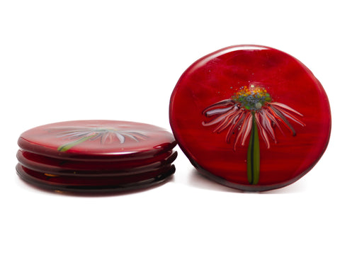 handmade glass coasters stacked three-high on the left side and one showing the top design of the image of echinacea flower on a red background on the right-hand side. image is on a white background.