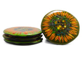 handmade glass coasters stacked three-high on the left side and one showing the top design of the image of a sunflower on a dark green glass background on the right-hand side. image is on a white background.