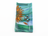flameworked and fused glass catch-all dish with sunflower design with earrings for scale.