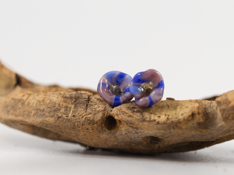 Detail of flower inspired flameworked glass earring studs. Shaped into Forget-Me-Nots in purples and blues.