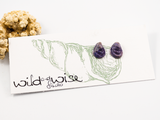 12mm flameworked glass earring studs in a deep purple colour displayed on an earring card.
