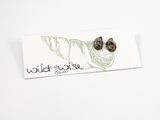 12mm mussel shell shaped flameworked glass earring studs in swirls of greys and charcoal displayed on an earring card..